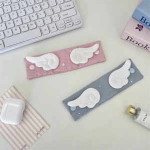 Detail of fabric cable organizers with plush angel wings and silver star patterns