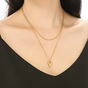 Close-up of 18K gold double-layered necklace with hammered heart pendant on model
