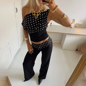 Detail of black polka dot fashion set with one-shoulder top and matching trousers