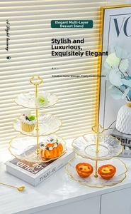 Detail of multi-layered glass dessert stand with gold trim and heart-shaped handle
