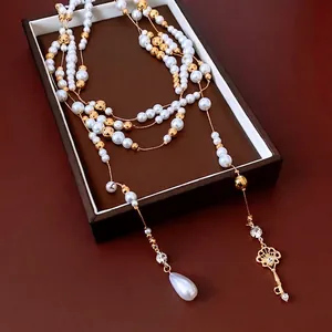 French style layered pearl necklace with gold beads and a vintage key pendant