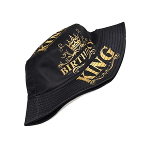 Détail d'un chapeau bob noir avec imprimé doré Birthday King et motif de couronne