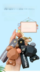 Detailed view of Nordic geometric bear keychains in black and brown with silicone straps