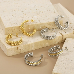 Detail showing twisted rope texture of the C-shaped earrings in gold and silver finish