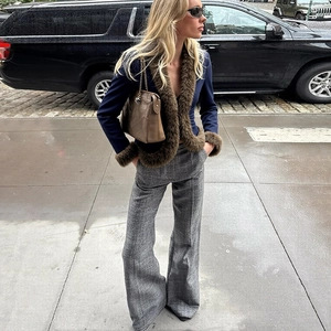 Street style shot of a slim fit navy jacket with faux fur trim paired with wide leg pants