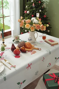 Bird's eye view of Christmas tablecloth with holly and bells pattern on festive set table