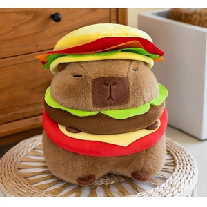 Cute brown capybara plush toy wearing a hamburger costume on a woven stool