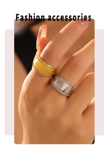 Close-up of gold and silver wide band rings with rhinestone edges worn by a model