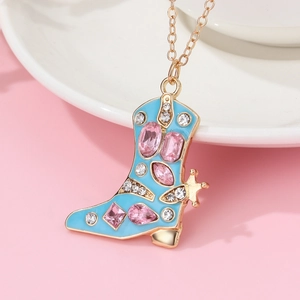 Dettaglio del ciondolo a stivale dorato con smalto blu e strass rosa su catenina d'oro