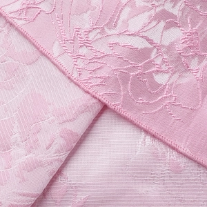Gros plan détaillé du tissu jacquard rose avec broderie florale et surpiqûre précise