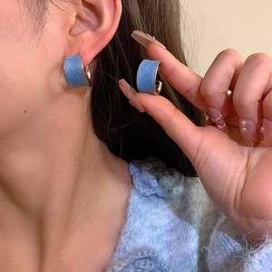 Blue marble resin C-shape hoop earrings with silver trim shown on a model