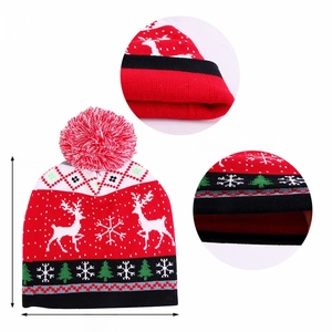 Detail showing red double-layer Christmas knit hat with reindeer pattern and pompom