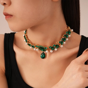 Detail of vintage emerald choker with pearl accents and large water drop gemstone pendant