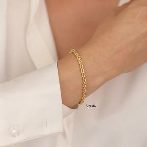 Detail of 18K gold plated stainless steel rope chain bracelet worn on a female wrist
