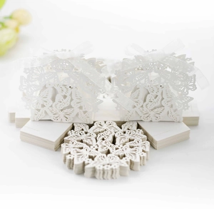 Laser-cut white wedding favor box with butterfly pattern and matching silk ribbon
