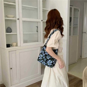 Close-up of blue floral jacquard shoulder bag showing the vintage canvas texture