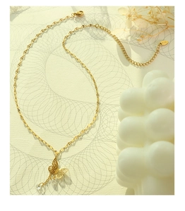 Macro detail of 18K gold-plated butterfly pendant with sparkling zircon droplet and K18 hallmark