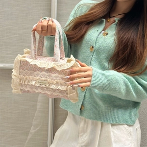 Détail du sac cabas en toile fleurie avec bordure en dentelle et étiquette de marque