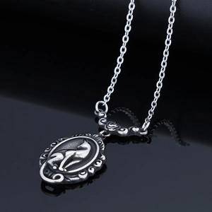 Elegant vintage stainless steel oval necklace with embossed cat design on mirror background