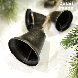 Close-up of vintage copper bells with rustic textured finish and natural hemp rope