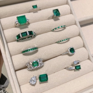 Varietà di anelli e orecchini vintage verde smeraldo in un vassoio di gioielli di lusso