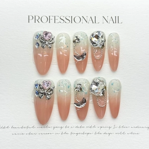 Handmade press-on nails with long stiletto shape, pink gradient, and luxury 3D crystal charms