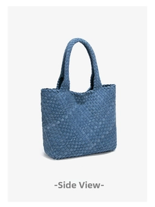 Detailed side view of dark blue denim woven tote bag with unique textured grid pattern