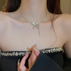 Close-up of a silver butterfly tassel necklace with sparkling zircons on a model