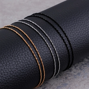 Minimalist 1mm stainless steel snake chains in gold, silver, and black on a leather stand