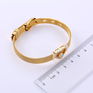 Golden mesh watch band bracelet with a sparkling heart-shaped evil eye pendant