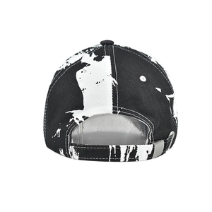 Close-up of adjustable metal buckle and black and white tie-dye pattern on the baseball cap
