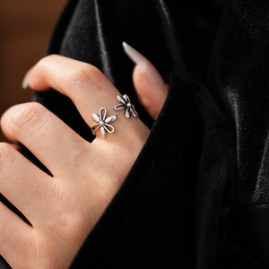 Close-up of vintage hollow flower open ring worn on hand with black velvet background