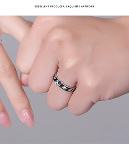 Close-up of astronaut couple ring with blue stone and celestial star patterns