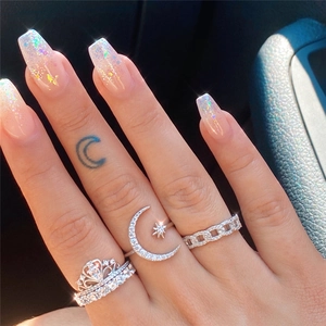 Detailed view of silver rings featuring crown and celestial moon star designs with rhinestones