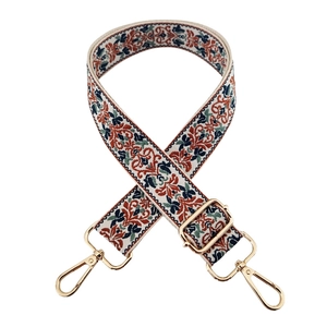 Close-up of ethnic jacquard embroidery strap with colorful patterns and gold metal hooks