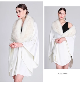 Close-up of white knit poncho featuring a premium faux fur collar and draped texture