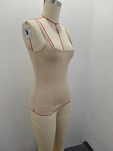 Detail of nude slim-fit camisole top with thin straps and seamless material on a mannequin