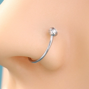 Close-up of a silver U-shaped stainless steel nose ring worn on a model's nose