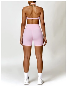 Detail of pink backless sports bra and high-waisted yoga shorts with scrunch butt effect