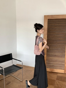 Pink woven bucket bag on model's shoulder showing size and natural drape