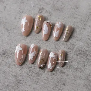 Close-up of pink butterfly nail stickers with gold foil and pearls on stone background