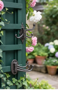 Detail showing vintage cast iron swivel hooks with three arms on a green wooden background