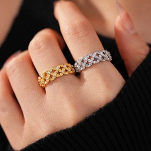 Detail of woven lattice rings in gold and silver plating with shimmering zircon stones