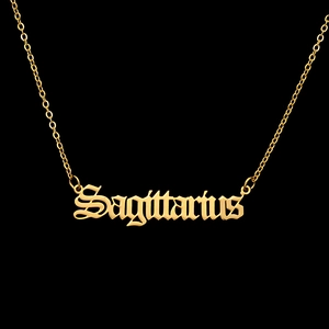 Detailed view of the gold Sagittarius gothic letter pendant on a delicate chain