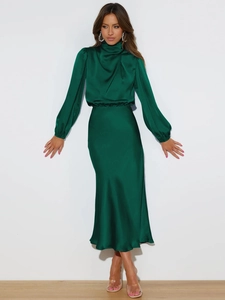 Detailed close-up of dark green satin dress featuring high neck and cuffed long sleeves