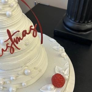 Christmas cake with red christmas lettering ribbon and white pearls decoration