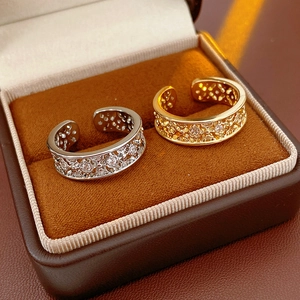 Macro shot of gold and silver plated open rings with hollow floral design and cubic zirconia