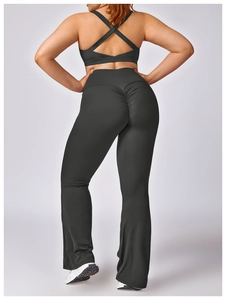 Detail of black high-waist flared yoga pants with ruched butt lift and cross-back sports top