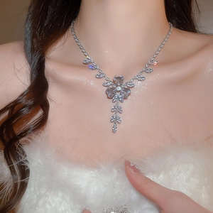 Detailed view of silver flower necklace with sparkling zircon tassels on a model
