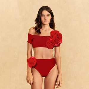 Detail of red two-piece swimsuit featuring large 3D rose floral decorations and high waist